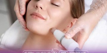 خانمی که خوابیده و چشم هایش بسته است و اپراتوری که با ذستکششیشه ای درحال لیزرکردن صورت خانم با لیزر فوتونا میباشد